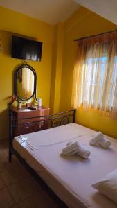 ein Schlafzimmer mit einem Bett, einer Kommode und einem Spiegel in der Unterkunft Polychrono Seaside Haven in Polychrono + 36 Fotos