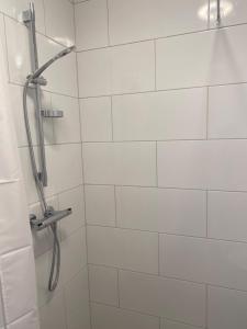 e bagno piastrellato bianco con doccia. di Pensionat bryggan a Smögen