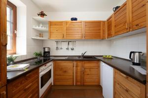 a kitchen with wooden cabinets and a sink at Ferienhaus May App 1 in Sahrensdorf