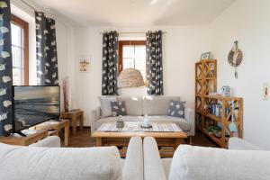 a living room with a couch and a tv at Ferienhaus May App 1 in Sahrensdorf +28 photos