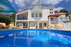 a villa with a swimming pool in front of a house at Sweet House in Mlini