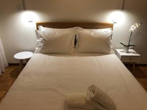 a bed with white sheets and pillows in a bedroom at Madorninha Urban Nest in Porto