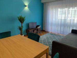 a living room with a table and a television at Madorninha Urban Nest in Porto