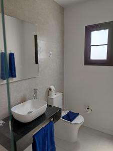 a bathroom with a sink and a toilet and a mirror at Casas Verol in Caleta De Fuste