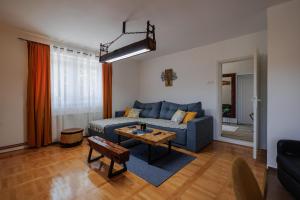 a living room with a blue couch and a table at Apartman Pepa in Pirot