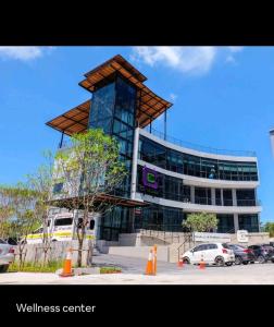 ein Gebäude mit einem Turm vor einem Parkplatz in der Unterkunft City Gate Apartments Kamala Beach Phuket Thailand - LMY in Ban Nong Chaeng
