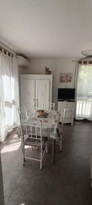 une salle à manger avec une table, des chaises et une télévision dans l'établissement Appartement climatisé Parc Paradis 150 m des thermes, à Gréoux-les-Bains