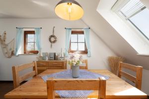 a dining room table with a vase of flowers on it at Ferienhaus May App 2 in Vitzdorf