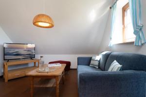 a living room with a blue couch and a tv at Ferienhaus May App 2 in Vitzdorf