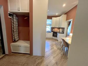 a kitchen with white cabinets and a table and a dining room at Villa Nelma in Ventspils