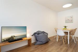 a living room with a flat screen tv on a wall at Waldstraße 8 Blue Ocean in Kellenhusen