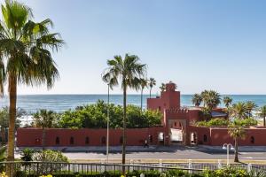 budynek na plaży z palmami i oceanem w obiekcie BenalBeach Premium Apartments by Alfresco Stays w mieście Benalmádena