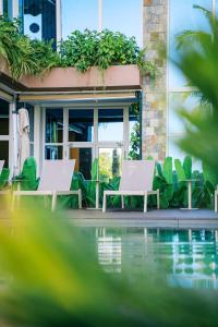 two chairs and a pool in front of a building at Anam Beach Resort in Calatagan