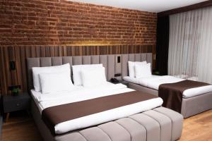 a bedroom with two beds and a brick wall at Vita Suites Karaköy in Istanbul +27 photos