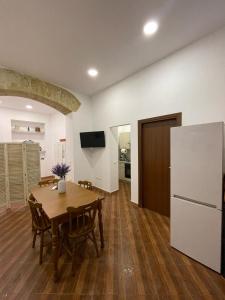 a kitchen and dining room with a table and a refrigerator at Violet House in Palermo