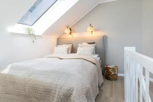 a bedroom with a bed with a skylight at Haus Baltic Flat White in Laboe