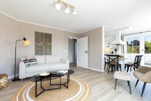 a living room with a white couch and a table at Haus Baltic Flat White in Laboe