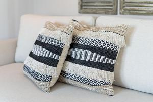 a black and white striped pillow on a couch at Haus Baltic Flat White in Laboe