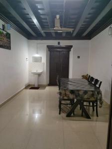 Habitación con mesa, sillas y puerta en Thiruvambady Heritage Homestay, en Trichūr