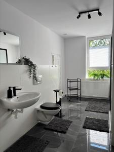 une salle de bain blanche avec toilettes et lavabo dans l'établissement YiPY Apartments am Landesmuseum Halle, à Halle-sur-Saale 22 autres photos