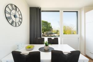 a dining room with a white table and a large clock at Beltblick in Marienleuchte