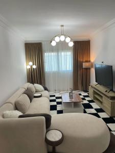 a living room with a couch and a tv at Rence Luxury Apartment in Cairo +2 photos