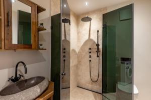 un baño con lavabo y ducha en Chalet Magdalena, en Kirchberg in Tirol