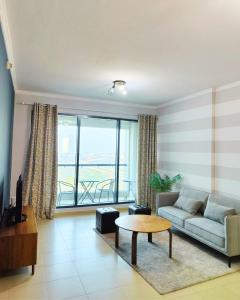 un soggiorno con un divano e un tavolo di Charming & Comfortable 1BR Jumeirah Bay X1 JLT a Dubai