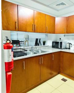 una cucina con armadi in legno e un idrante rosso di Charming & Comfortable 1BR Jumeirah Bay X1 JLT a Dubai