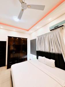 a bedroom with a bed and a ceiling fan at Golden Crystal Hotel in Accra +5 photos