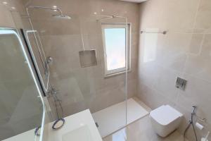 Un baño con ducha, inodoro y ventana. en Villa Dantas by amcf, en Vilamoura 36 fotos más