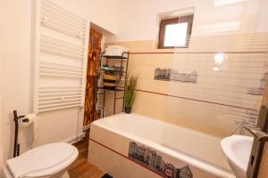 a bathroom with a tub and a toilet and a sink at Casa Walter Ultracentral - Terasă Privată in Curtea de Argeş +40 photos