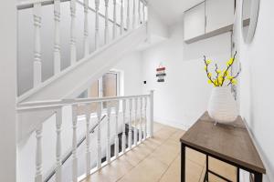 a white staircase with a vase on a table at Bright 4BR 2BA Gem in Wembley Harrow - Sleeps 8 in Kenton
