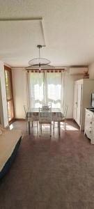 une salle à manger avec une table et des chaises dans une pièce dans l'établissement Appartement climatisé Parc Paradis 150 m des thermes, à Gréoux-les-Bains