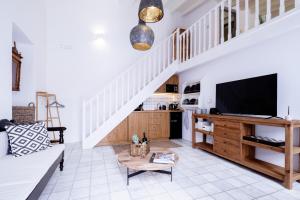 a living room with a couch and a tv at Mea Casa Halki in Halki