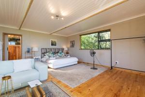 a living room with a couch and a bed at Kyles Forest Cabin in Kafferkop