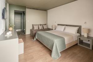 a bedroom with a large bed and a couch at Amalia Hotel Delphi in Delfoi