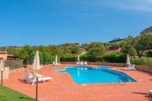 a large swimming pool with chairs and umbrellas at Mono 4 pax - Terrazza - Piscina & Parcheggio in Baja Sardinia