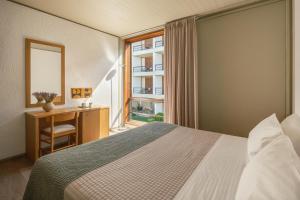 a hotel room with a bed and a window at Amalia Hotel Delphi in Delfoi