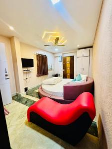 a room with two beds and a red chair at Hotel Elite Stay - Nilanjali Society, Kalyani Nagar, Pune in Pune