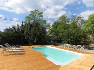 einen Pool auf einer Holzterrasse mit Stühlen und einem Pool in der Unterkunft Gite Mas Sophia in Labeaume