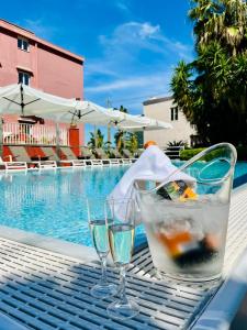 a table with two glasses next to a swimming pool at Palatium Mari in Capri