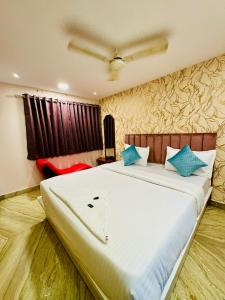 a bedroom with a large bed with blue pillows at Hotel Elite Stay - Nilanjali Society, Kalyani Nagar, Pune in Pune