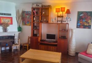 a living room with a tv and a table at CASA MILFONTES by Stay in Alentejo in Vila Nova de Milfontes