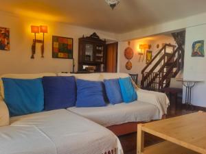 a living room with a white couch with blue pillows at CASA MILFONTES by Stay in Alentejo in Vila Nova de Milfontes