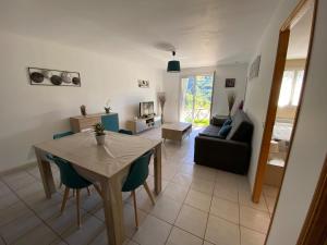 a living room with a table and a couch at Chez Virginie et Christophe in Belvédère