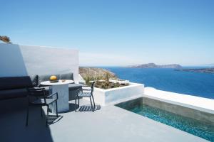 a patio with a table and chairs and the ocean at Santonero in Akrotiri