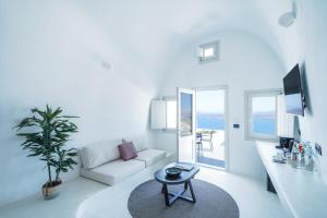 a white living room with a couch and a table at Santonero in Akrotiri