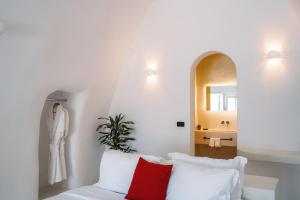 a bedroom with a bed with red and white pillows at Santonero in Akrotiri