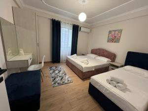 a hotel room with two beds and a couch at Villa Sarvi in Durrës